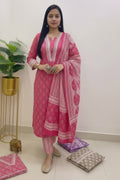 Woman wearing a pink patterned outfit with text indicating size range and reference image note.