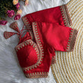 Red embroidered blouse on a textured surface with flowers