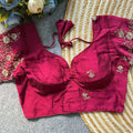 Red embroidered blouse on a textured surface with flowers in the background