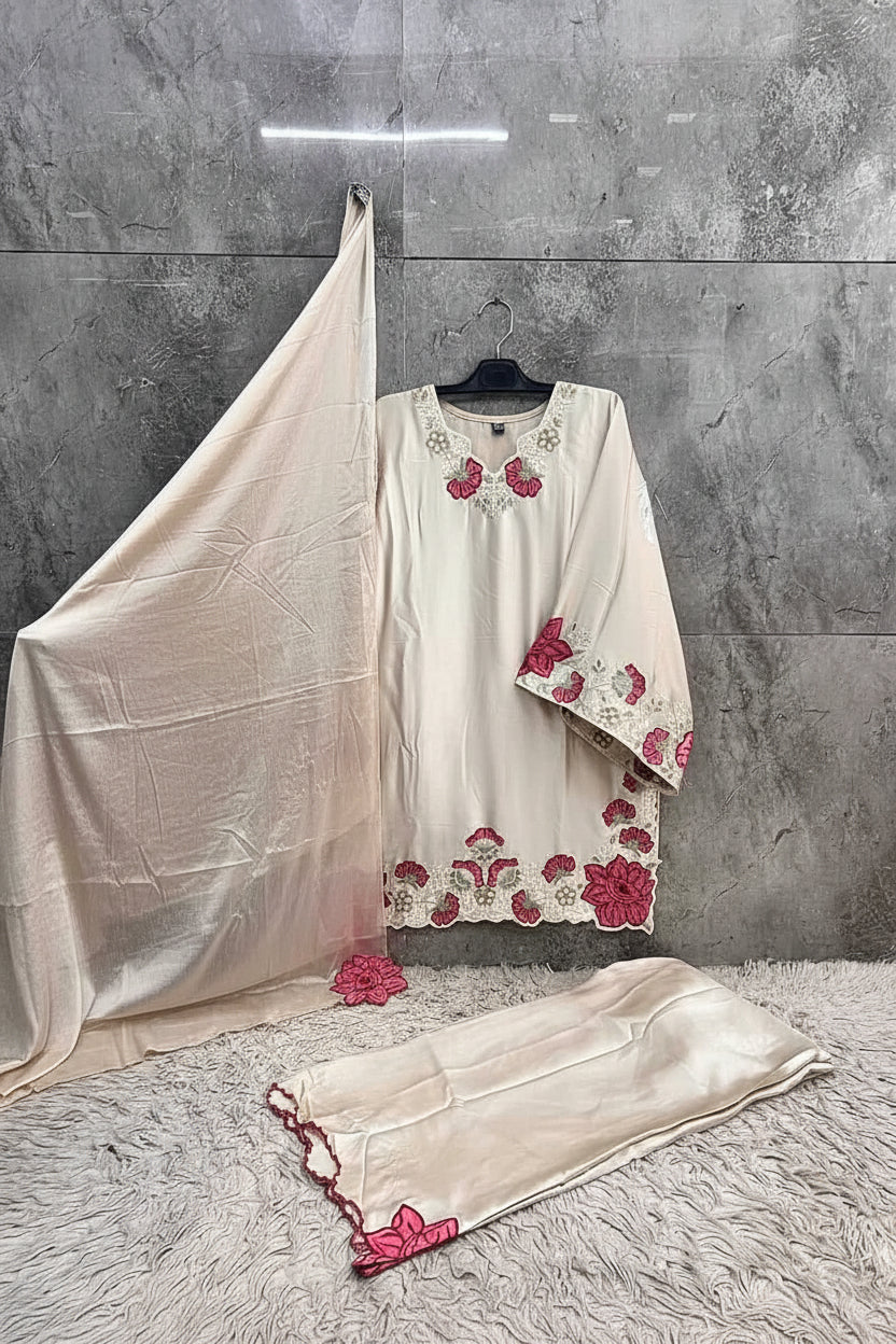 White embroidered dress with red floral patterns on a gray floor and wall.