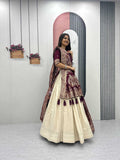 Woman in a traditional outfit standing in front of a mirror with a neutral background