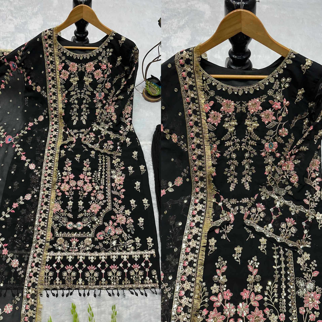 Two black embroidered garments on hangers against a light background