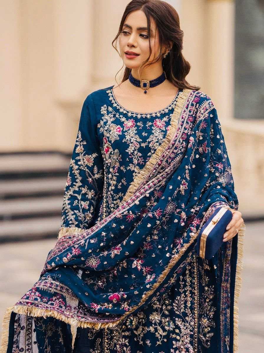 Woman wearing a traditional blue embroidered outfit with a blurred architectural background