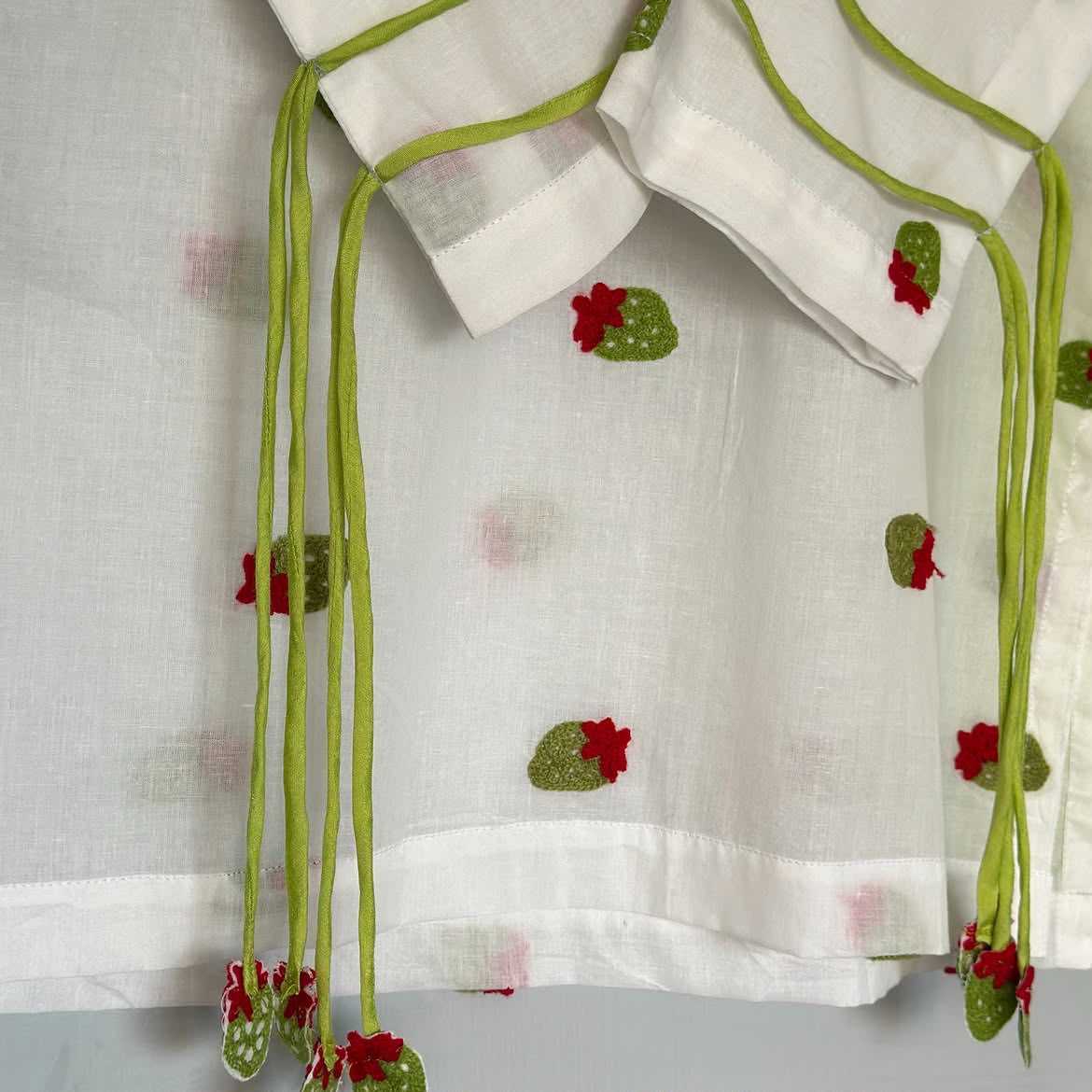 White cotton kurta with embroidered green cactus motifs and red flowers, featuring green drawstring ties.