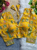 Yellow floral blouse with matching pants on a textured surface with flowers and leaves.