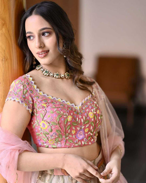 Woman wearing a pink embroidered blouse with a blurred background