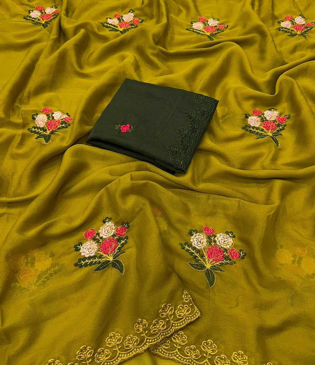 A draped olive green fabric with embroidered floral motifs in pink, red, and white, featuring a folded black fabric piece with matching embroidery placed on top.