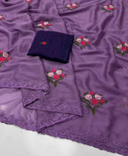 Purple embroidered fabric with floral motifs and a matching dark purple folded fabric piece on a white surface.