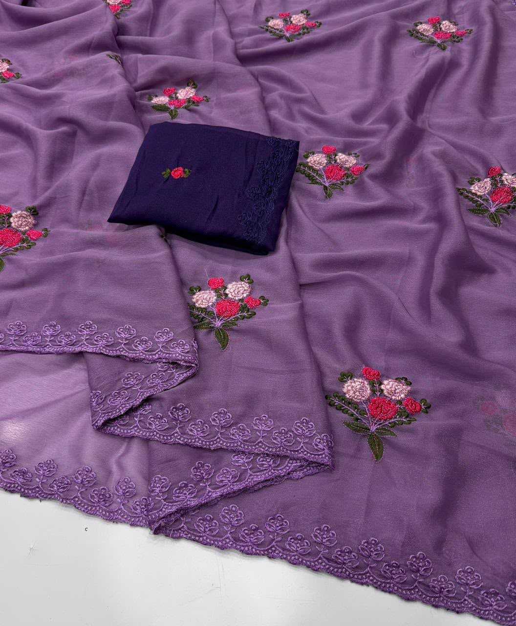 Purple embroidered fabric with floral motifs and a matching dark purple folded fabric piece on a white surface.