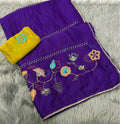 Purple embroidered fabric set with a matching yellow cloth, laid flat on a gray faux fur background. The purple fabric features multicolor floral embroidery and silver mirror work borders.