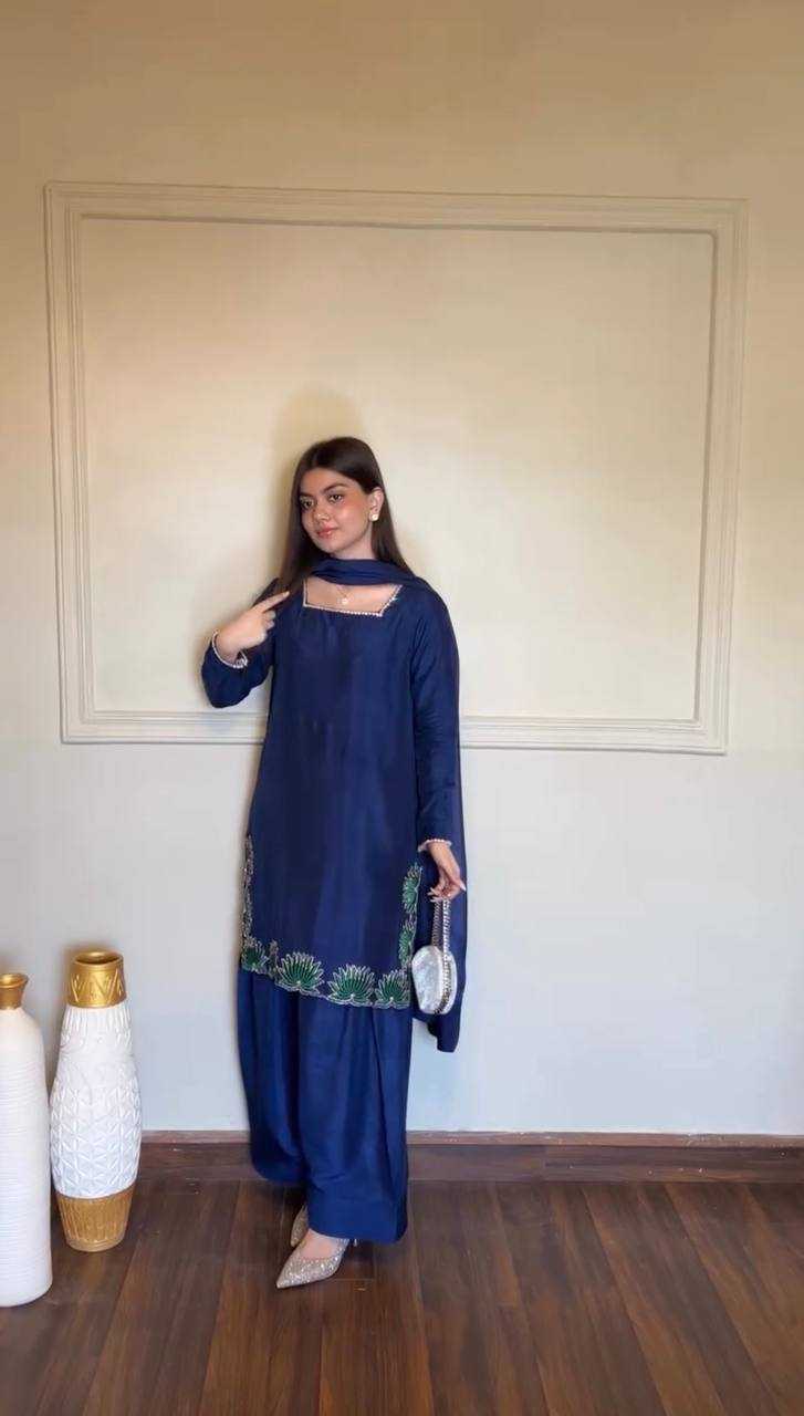 Woman in a blue traditional outfit standing in a room with decorative vases.