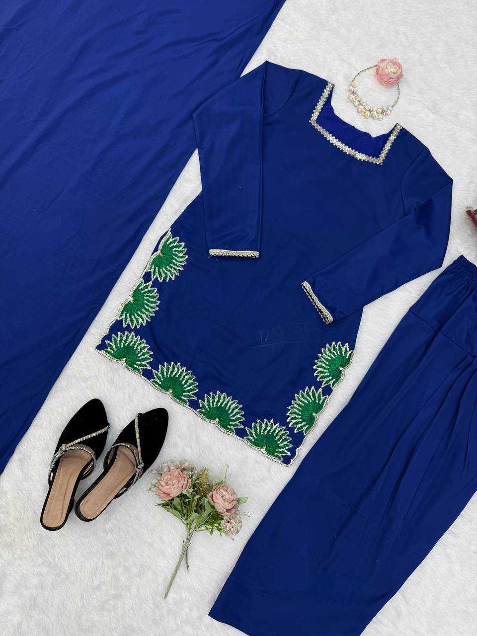 Blue embroidered outfit with pants, top, and slippers on a white surface.