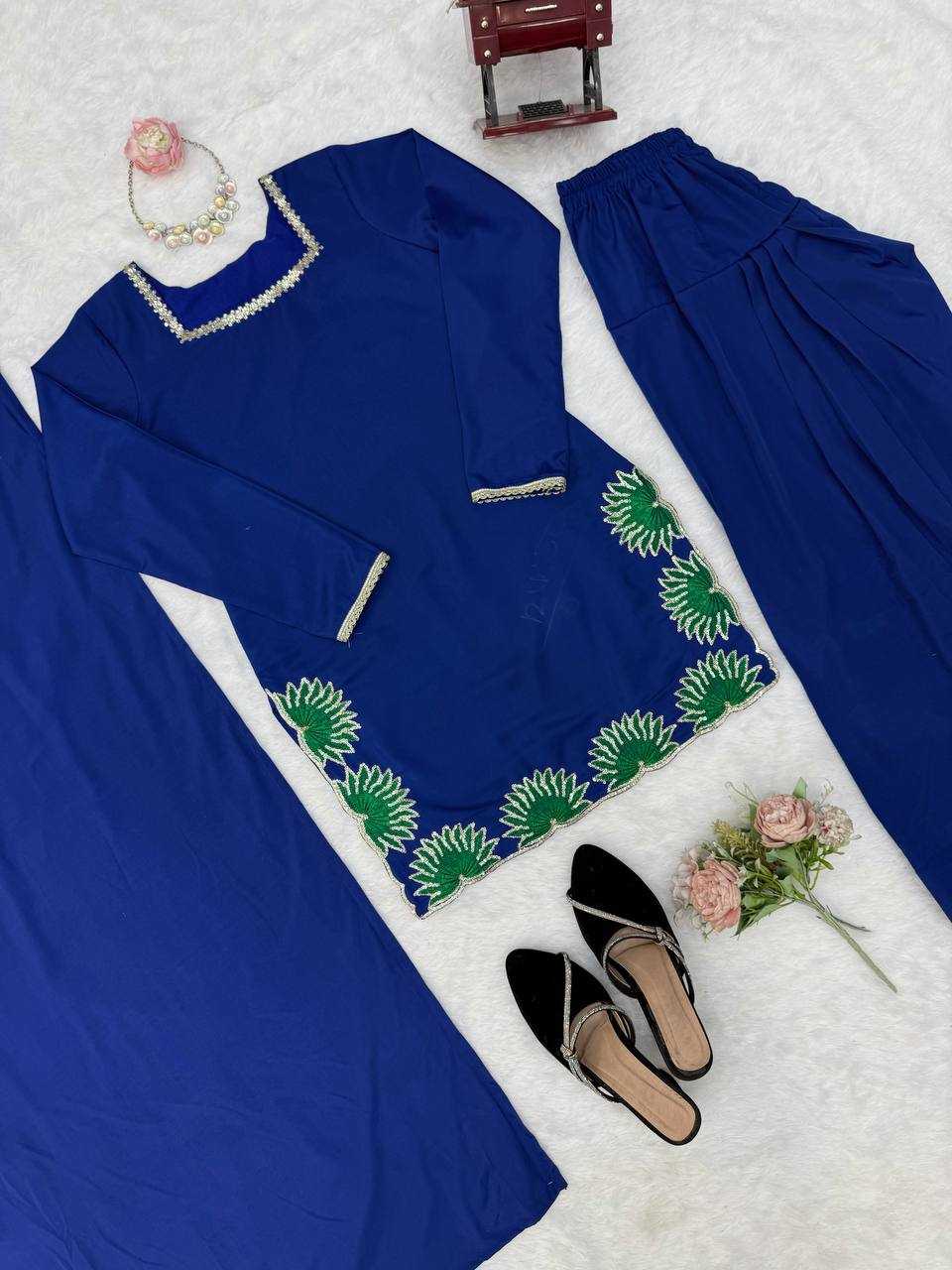 Blue outfit with green embroidery on a white surface with accessories.
