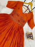 Orange embroidered dress on a white surface with a decorative box.