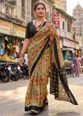 Woman in a traditional saree walking on a street with shops and vehicles in the background