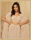 Woman in a beige traditional outfit with a matching shawl against a beige background